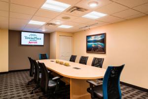 a conference room with a table and chairs and a screen at TownePlace Suites by Marriott Red Deer in Red Deer