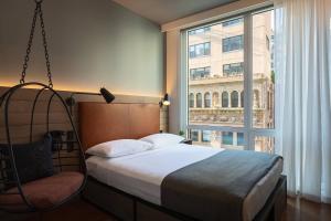 a bedroom with a swinging bed and a large window at Moxy NYC Downtown in New York