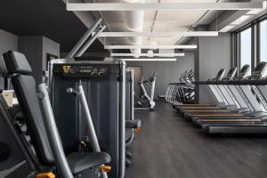 a gym with a row of treadms and cardio machines at Renaissance Milwaukee West Hotel in Wauwatosa