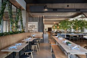 a restaurant with wooden tables and chairs and plants at Renaissance Milwaukee West Hotel in Wauwatosa