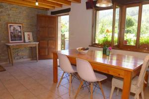 ein Esszimmer mit einem Holztisch und Stühlen in der Unterkunft Casa Rural Nel NRGA002R in Bojes