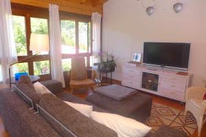 ein Wohnzimmer mit Couch und Flachbildfernseher in der Unterkunft Casa Rural Nel NRGA002R in Bojes
