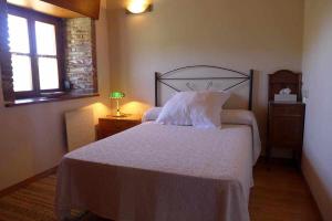 ein Schlafzimmer mit einem weißen Bett und einem Fenster in der Unterkunft Casa Rural Nel NRGA002R in Bojes