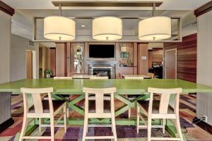 uma sala de jantar com uma grande mesa verde e cadeiras em Fairfield Inn & Suites by Marriott Edison - South Plainfield em Edison