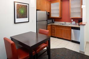 cocina con mesa y nevera en Residence Inn Harrisburg Hershey, en Harrisburg