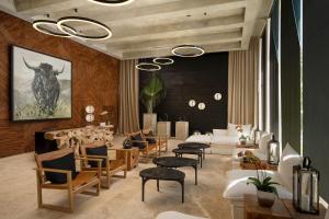 a living room with chairs and tables and a painting at The Ocean Club, a Luxury Collection Resort, Costa Norte in Sosúa