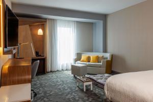 une chambre d'hôtel avec un lit et un canapé dans l'établissement Courtyard by Marriott Mexicali, à Mexicali