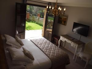 a bedroom with a bed and a desk and a television at El Rincón de Escalante in Escalante