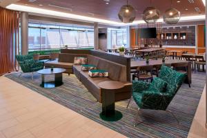 a lobby with couches and tables and a bar at SpringHill Suites by Marriott East Lansing University Area, Lansing Area in East Lansing