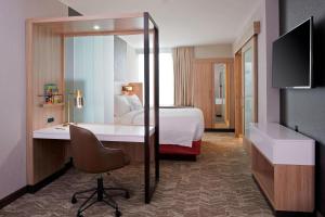 a hotel room with a bed and a desk with a chair at SpringHill Suites by Marriott East Lansing University Area, Lansing Area in East Lansing