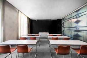 una sala de conferencias con mesas y sillas blancas en AC Hotel Burgos by Marriott, en Burgos