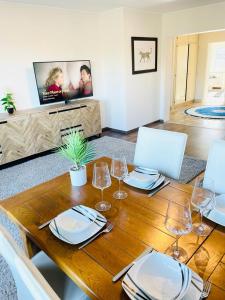 a wooden table with plates and wine glasses on it at Big Penthouse 2 Bedrooms in Center with Parking and LargeTerrace-41 in Luxembourg
