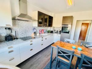 a kitchen with white cabinets and a wooden table at Big Penthouse 2 Bedrooms in Center with Parking and LargeTerrace-41 in Luxembourg