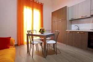 een keuken met een tafel en stoelen in een kamer bij B&B La Grande Mela in Santo Stefano di Camastra