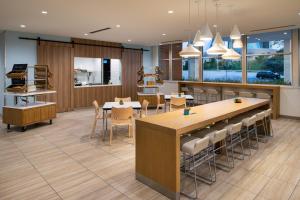 a kitchen and dining room with tables and chairs at Element Kansas City Overland Park in Leawood