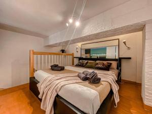1 Schlafzimmer mit 2 Betten und einem großen Spiegel in der Unterkunft [S.Orsola] Industrial Design Suite* * * * * in Bologna