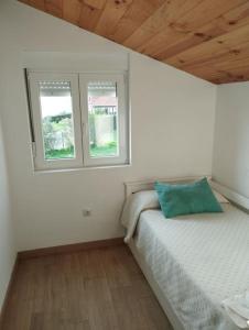 a bedroom with two beds and two windows at CASITA INDEPENDIENTE EN SUANCES Parking - Wifi - Jardín in Cortiguera