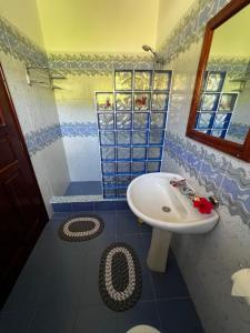 baño azul y blanco con lavabo en Sunset Cove Villa, en Grand'Anse Praslin