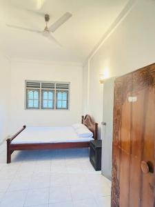 a bedroom with a bed and a window at Susha Happy One 2BR First Floor Apartment in Hikkaduwa