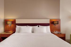 a large bed in a hotel room with two lamps at Courtyard by Marriott Zurich North in Zurich