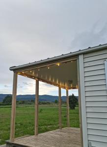 una terraza con toldo y luces en una casa en Bungalow au pied du Luberon, en Saint-Martin-de-la-Brasque