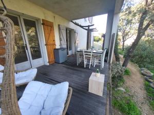 een veranda met stoelen en een tafel op een huis bij Bas de villa proche Ajaccio in Bastelicaccia