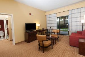 a living room with a couch and a table and a television at Courtyard Florence South Carolina in Florence