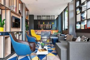 a lobby with blue and yellow chairs and tables at Courtyard by Marriott Zurich North in Zurich