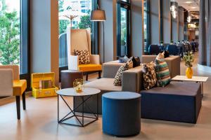 a lobby with couches and tables and windows at Courtyard by Marriott Zurich North in Zurich