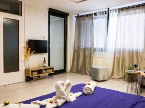a living room with a towel animal laying on a purple rug at Center Cozy Apartment in Subotica