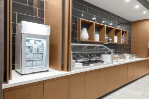 a kitchen with a stove and a refrigerator at SpringHill Suites by Marriott Raleigh Apex in Apex