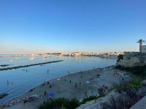a group of people on a beach near the water at La Casa di Szà in Otranto