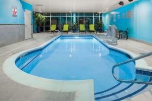 埃佩克斯SpringHill Suites by Marriott Raleigh Apex的大楼里的大型游泳池，水是蓝色的