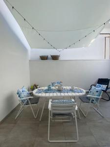 a table and chairs in a room with a white ceiling at La Casa di Szà in Otranto