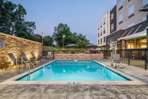 a swimming pool with chairs and a building at Fairfield by Marriott Inn & Suites Albertville in Albertville