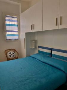 a bedroom with a blue bed and a window at La Casa di Szà in Otranto