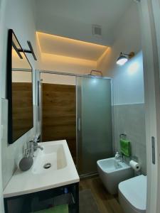 a bathroom with a sink and a toilet and a mirror at La Casa di Szà in Otranto