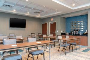 a conference room with tables and chairs and a flat screen tv at Fairfield Inn & Suites by Marriott Indianapolis Carmel in Carmel