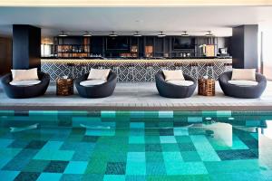 a living room with a pool and two chairs and a kitchen at AC Hotel by Marriott Veracruz in Veracruz