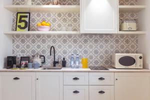 a kitchen with white cabinets and a microwave at Samaritana Suites in Palma de Mallorca