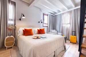 a bedroom with a large bed with orange pillows at Samaritana Suites in Palma de Mallorca