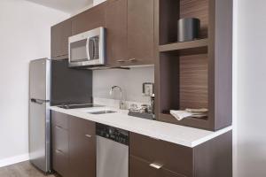 a kitchen with a stainless steel refrigerator and a microwave at TownePlace Suites by Marriott Medicine Hat in Medicine Hat