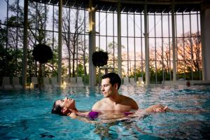 un hombre y una mujer en una piscina en Luxury Spa Hotel - Francofolies, en Spa