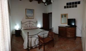 a bedroom with a bed and a tv and a chair at A Casa di Marti in Loreto
