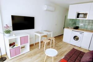 a living room with a tv and a table and chairs at Pink 430 in Playa del Ingles