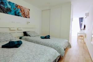 a bedroom with two beds and a painting on the wall at Pink 430 in Playa del Ingles