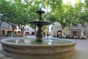 a fountain in the middle of a plaza at Le Mas du Berger in Saint-Quentin-la-Poterie