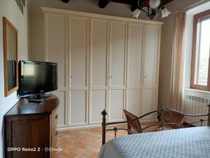 1 dormitorio con TV en la parte superior de un tocador en A Casa di Marti, en Loreto