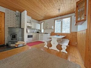 a kitchen with a white table and a fireplace at Riihilampi in Muurame