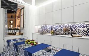 una cucina con tavoli blu e armadietti bianchi di Il Reticolo a Salerno